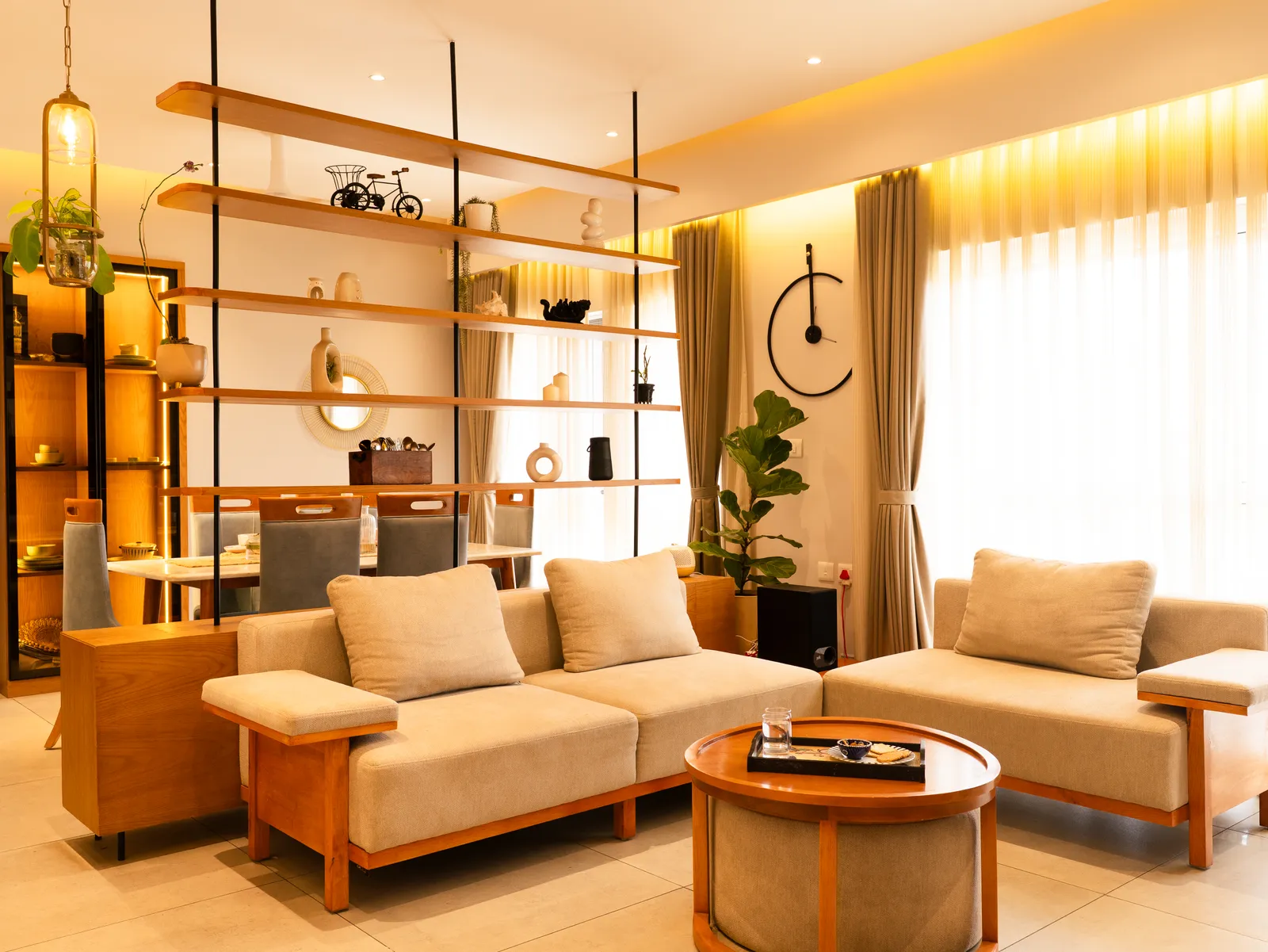 Living room with oak-frame sofas and suspended shelving — Amlan's Residence